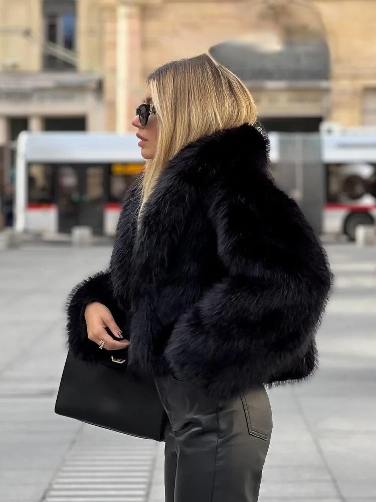 Chic woman wearing an artificial fur cropped winter coat with stylish sunglasses in a city setting