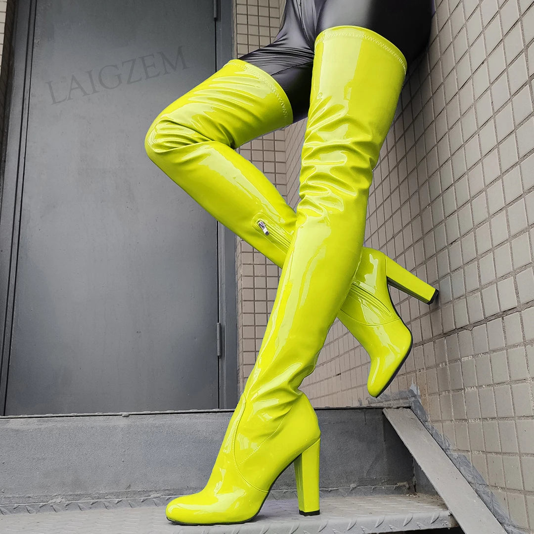 Bright yellow shiny thigh high boots with a sleek design and high heels for a bold fashion statement