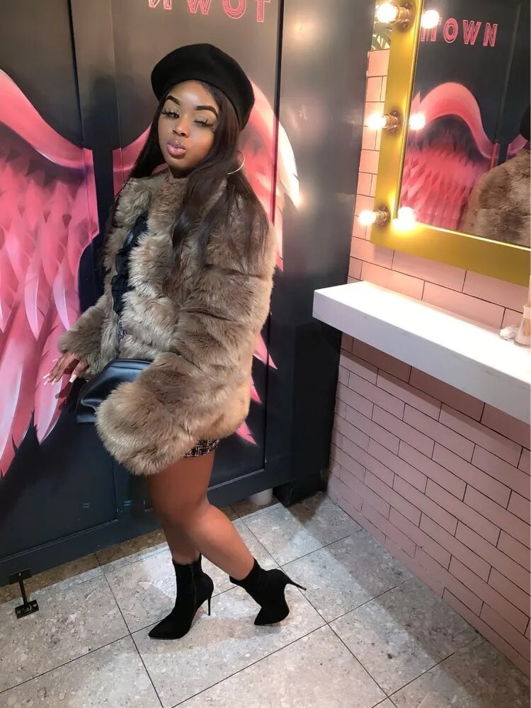 Stylish woman wearing a luxury faux fur coat with chic black heels in a trendy setting