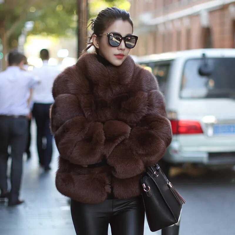 Stylish luxury faux fur coat in brown worn by a model with sunglasses on a city street