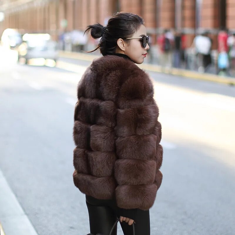 Stylish woman wearing a luxury faux fur coat in brown on a city street