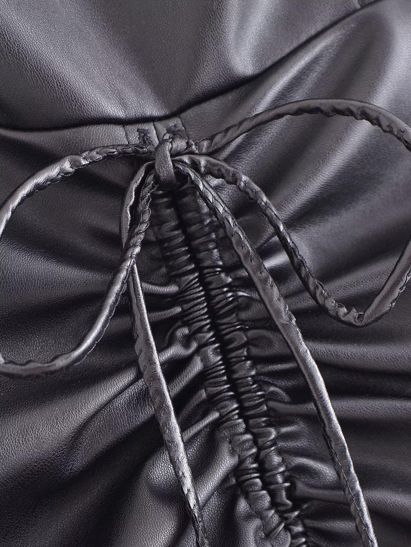 Close-up of the drawstring faux leather dress showcasing the tied detail and ruched fabric design