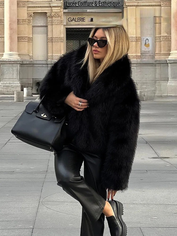 Chic model wearing artificial fur cropped winter coat, paired with black leather pants and oversized sunglasses