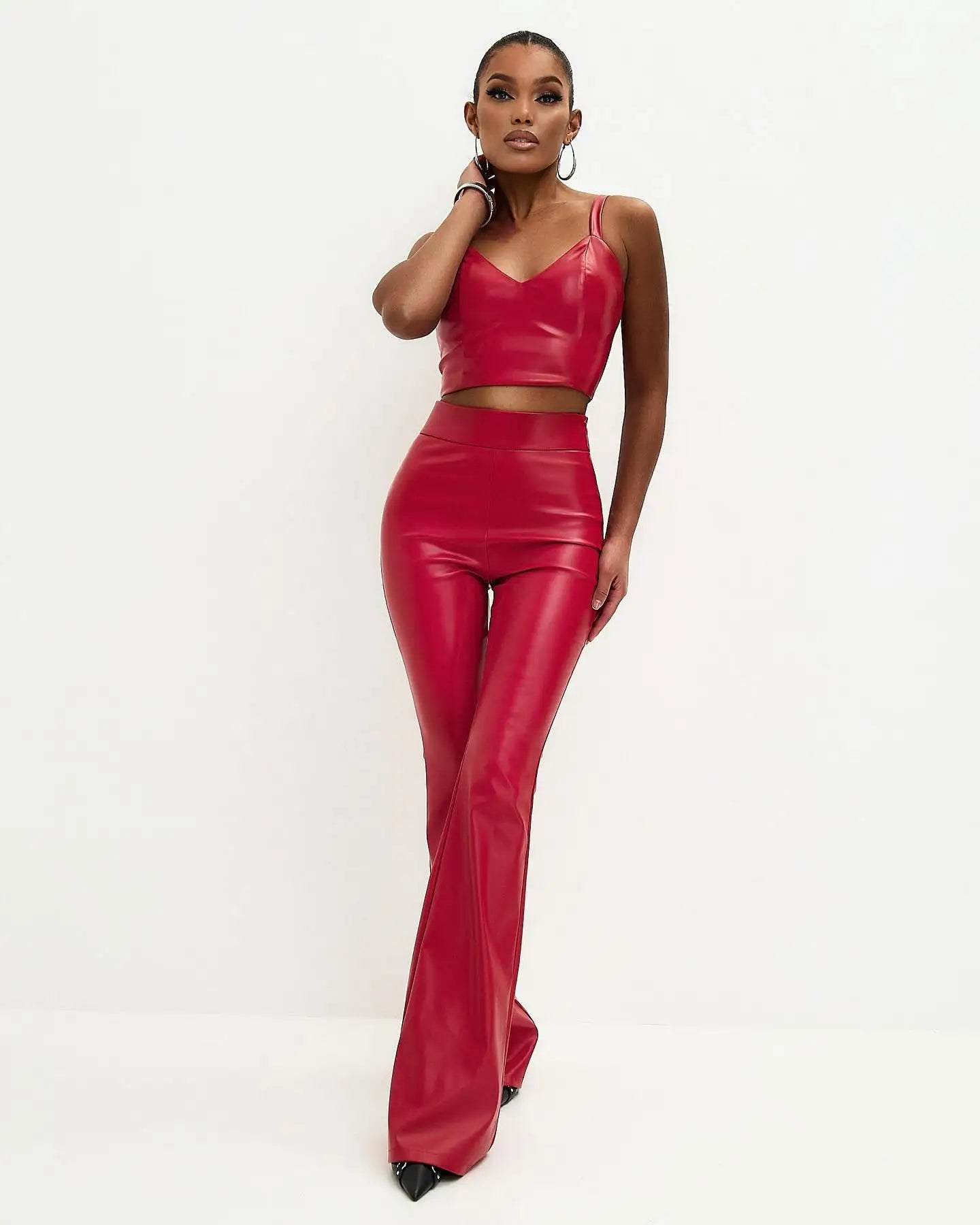 Model wearing Flared High Waist PU Leather Trousers in red, paired with a matching crop top for a stylish look