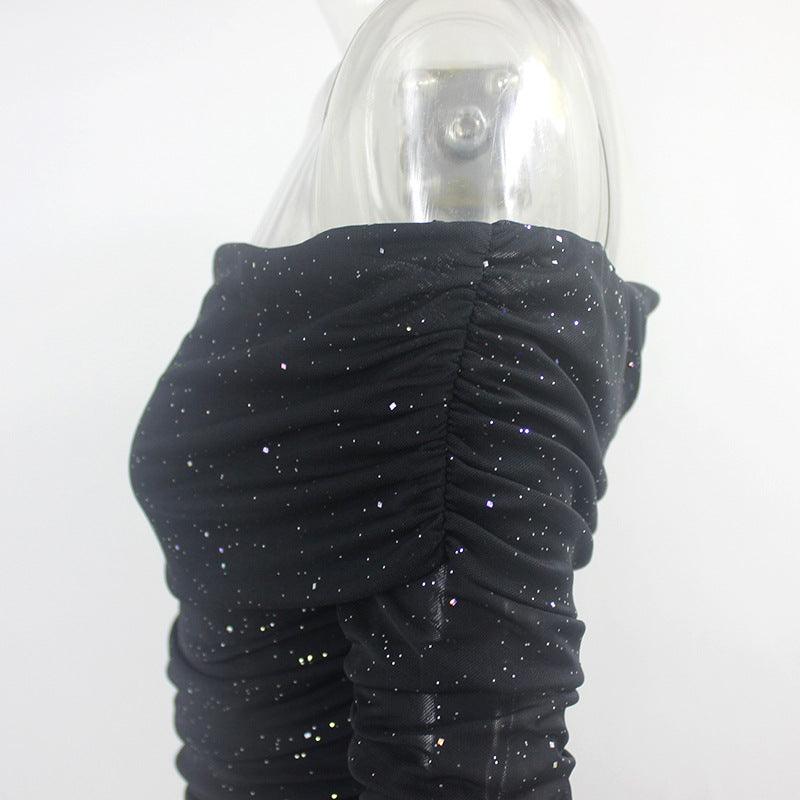 Close-up of a black off-shoulder evening dress featuring ruched detailing and sparkling accents