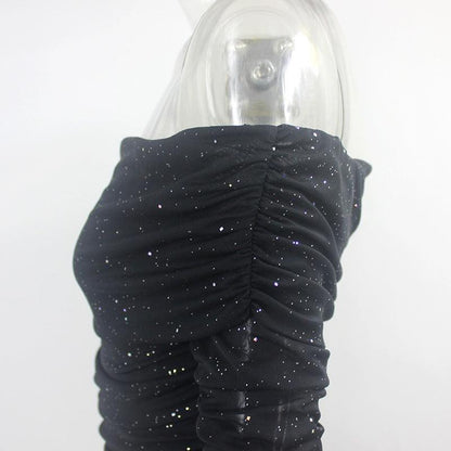 Close-up of a black off-shoulder evening dress featuring ruched detailing and sparkling accents